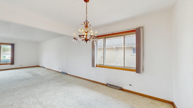 carpeted empty room with baseboards, a chandelier, and visible vents