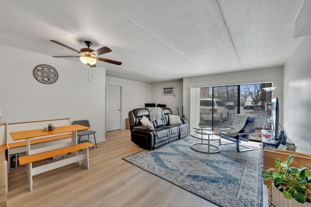 7117 W 93rd St Unit 102, Oak Lawn, IL 60453 - living area with baseboards, an AC wall unit, a ceiling fan, a textured ceiling, and wood finished floors