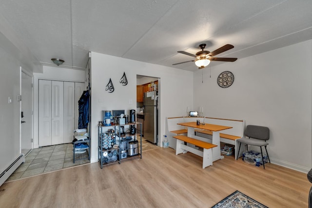 7117 W 93rd St Unit 102, Oak Lawn, IL 60453 - dining room with light wood finished floors, baseboard heating, baseboards, and ceiling fan