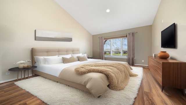 bedroom with baseboards, high vaulted ceiling, and light wood-style flooring