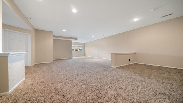 spare room with baseboards, light carpet, recessed lighting, and visible vents