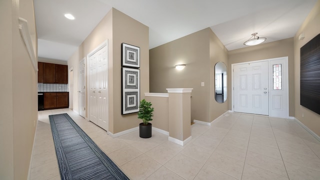 foyer featuring light tile patterned flooring and baseboards
