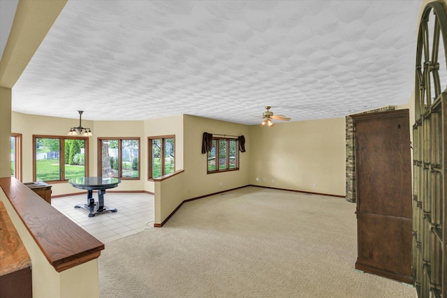 1801 Bentbrook Dr, Champaign, IL 61822 - unfurnished living room featuring carpet floors, plenty of natural light, baseboards, a ceiling fan, and a textured ceiling