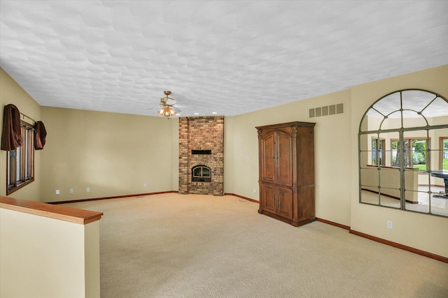 1801 Bentbrook Dr, Champaign, IL 61822 - unfurnished living room featuring a ceiling fan, baseboards, a fireplace, a textured ceiling, and light carpet