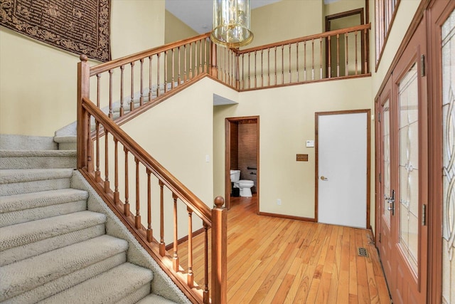 1801 Bentbrook Dr, Champaign, IL 61822 - stairway with wood-type flooring, a high ceiling, a chandelier, and baseboards