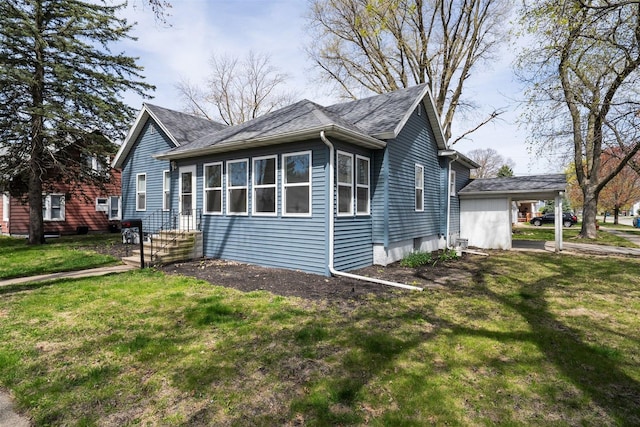 view of front of property with roof with shingles and a front yard