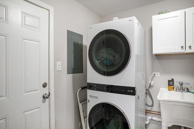 6226 Beechwood Rd, Matteson, IL 60443 - laundry room featuring cabinet space, stacked washer and dryer, electric panel, and a sink