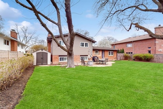 back of property with a patio area, a yard, a fenced backyard, a storage shed, and brick siding