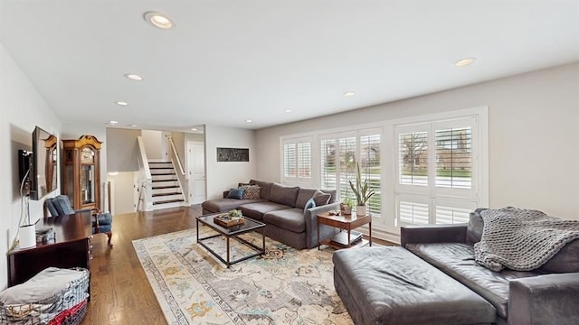 living area with recessed lighting, stairs, and wood finished floors