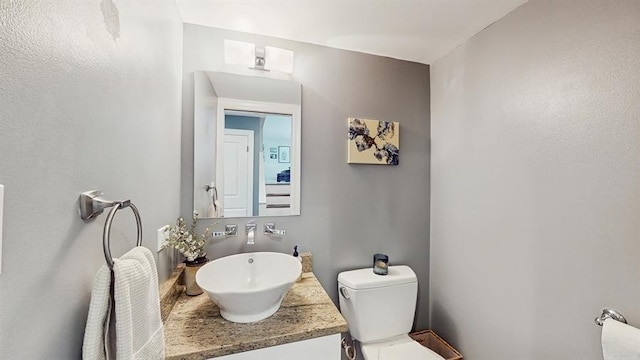 half bathroom with toilet and vanity
