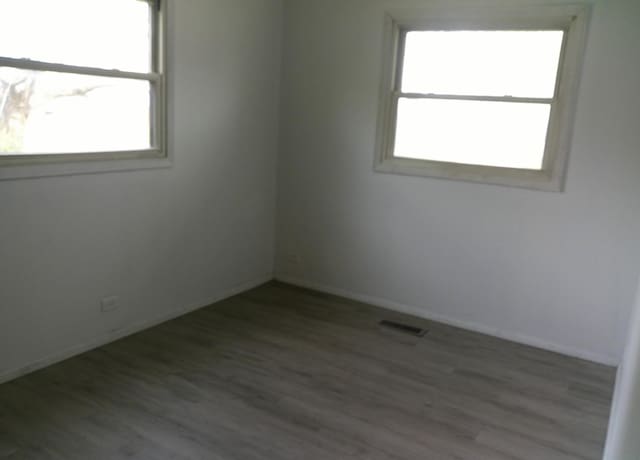 1507 Thornton Dr, Champaign, IL 61821 - unfurnished room with a healthy amount of sunlight, wood finished floors, and visible vents