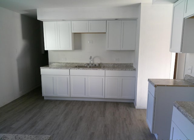 1507 Thornton Dr, Champaign, IL 61821 - kitchen featuring light countertops, wood finished floors, a sink, and white cabinetry