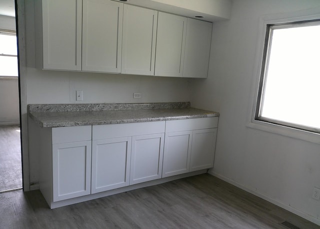 1507 Thornton Dr, Champaign, IL 61821 - kitchen with visible vents, white cabinets, baseboards, light countertops, and light wood-style flooring