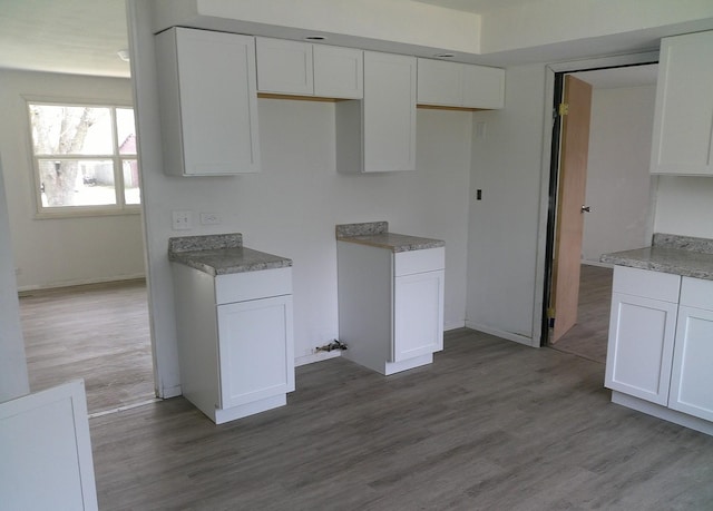 1507 Thornton Dr, Champaign, IL 61821 - kitchen with wood finished floors, baseboards, and white cabinetry