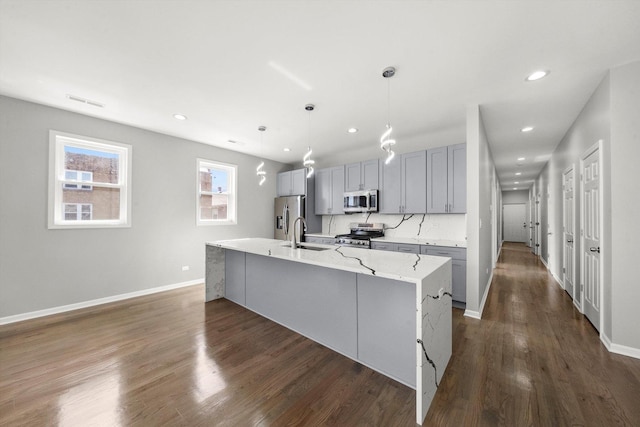 2200 N Kildare Ave, Chicago, IL 60639 - kitchen featuring a sink, dark wood-style flooring, appliances with stainless steel finishes, gray cabinetry, and a center island with sink