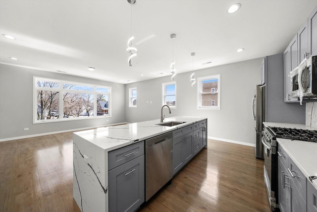 2200 N Kildare Ave, Chicago, IL 60639 - kitchen featuring a sink, a kitchen island with sink, stainless steel appliances, gray cabinets, and light stone counters