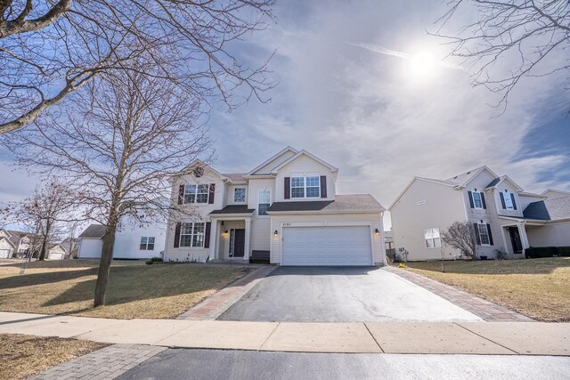 view of front facade with a front lawn, an attached garage, and driveway