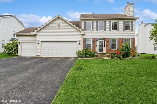 view of front of property featuring a front yard, an attached garage, a chimney, brick siding, and driveway