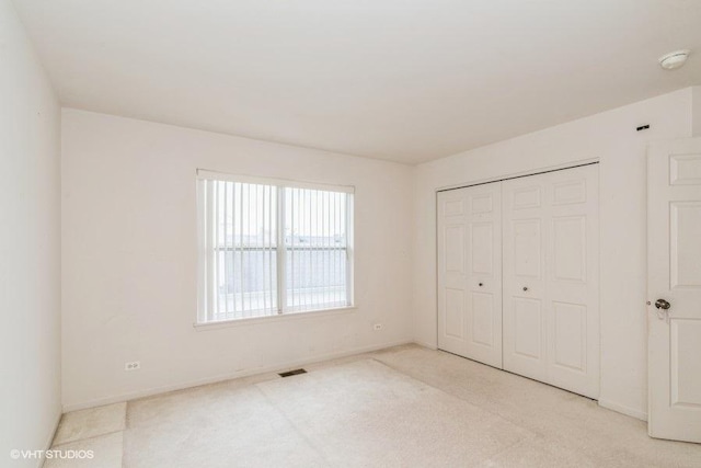 unfurnished bedroom featuring visible vents, baseboards, and carpet floors