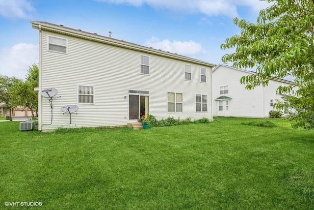 rear view of house featuring central AC and a lawn