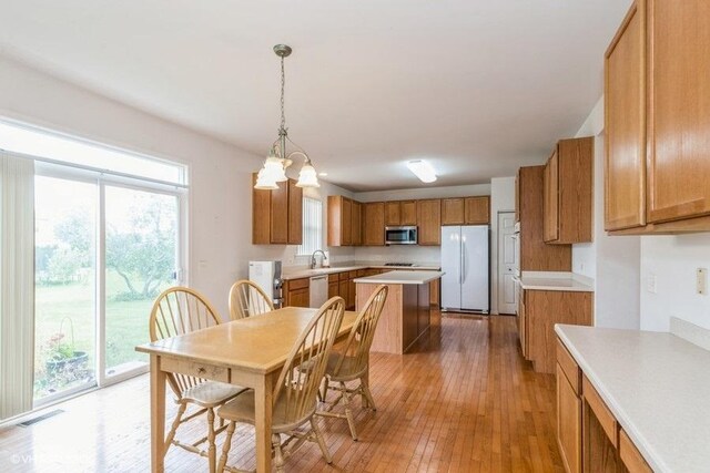dining room featuring visible vents, light wood finished floors, an inviting chandelier, and a healthy amount of sunlight