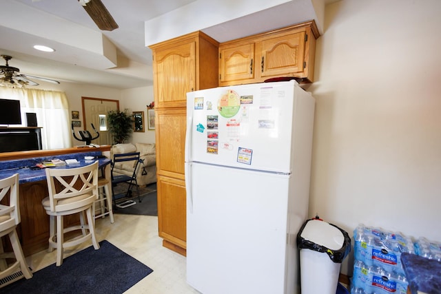 kitchen with recessed lighting, freestanding refrigerator, a ceiling fan, and light floors