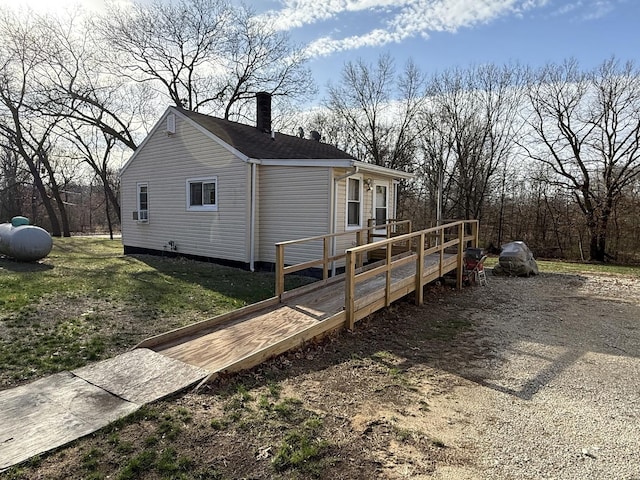 view of property exterior featuring a chimney and a deck