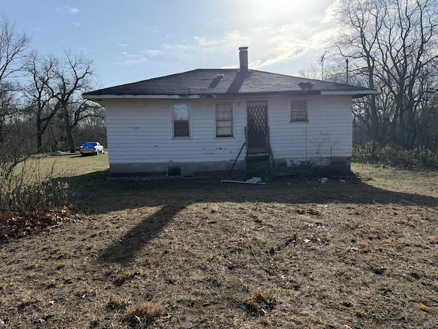 back of property with entry steps and roof with shingles