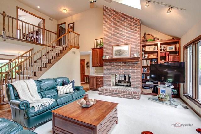 16737 W Cherrywood Ln, Wadsworth, IL 60083 - carpeted living area featuring high vaulted ceiling, plenty of natural light, stairway, and a fireplace