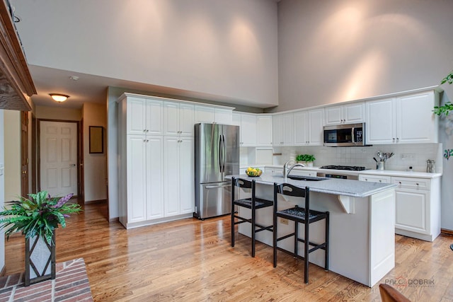 16737 W Cherrywood Ln, Wadsworth, IL 60083 - kitchen featuring appliances with stainless steel finishes, a high ceiling, white cabinets, and a kitchen breakfast bar