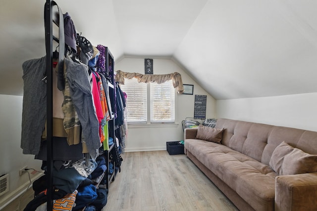 interior space with wood finished floors, lofted ceiling, and baseboards