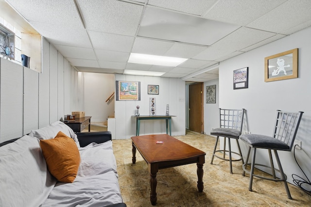 living room with a drop ceiling and stairs