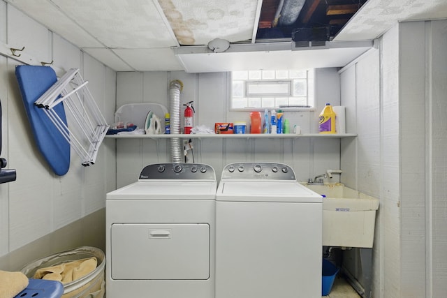 washroom with a sink, washer and clothes dryer, and laundry area