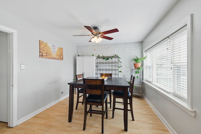dining area with light wood-type flooring, baseboards, and ceiling fan