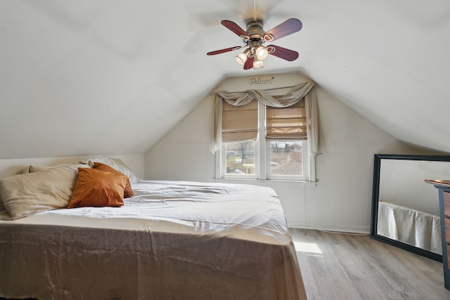 bedroom with vaulted ceiling, light wood-style floors, and a ceiling fan