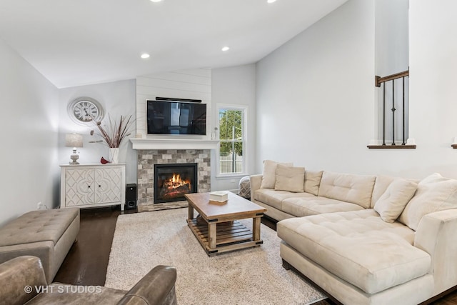 living room featuring lofted ceiling, recessed lighting, and a fireplace