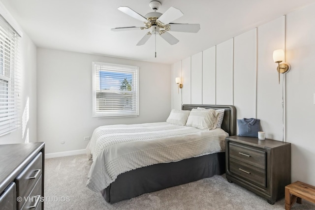 bedroom featuring light colored carpet, baseboards, and a ceiling fan