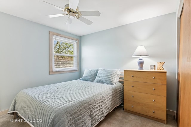 bedroom featuring light colored carpet and a ceiling fan