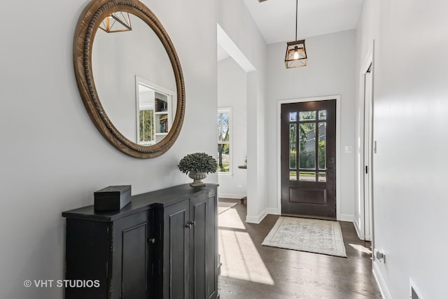 foyer featuring dark wood-style flooring and baseboards