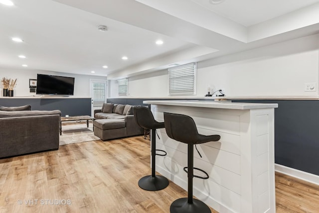 bar area featuring light wood-style floors, recessed lighting, and baseboards