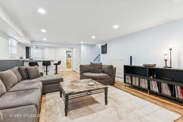 living room featuring light wood-type flooring, recessed lighting, baseboards, and baseboard heating