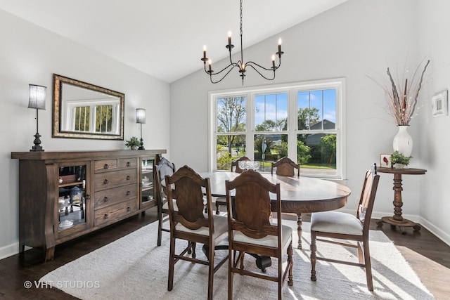 dining area featuring a chandelier, lofted ceiling, dark wood-type flooring, and baseboards