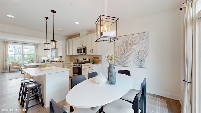 405 Filson St, La Grange, IL 60525 - dining space with light wood-style floors, recessed lighting, baseboards, and an inviting chandelier