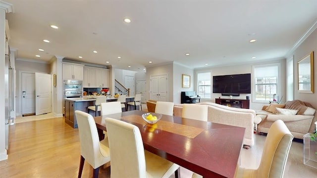 dining area featuring light wood-style floors, ornamental molding, stairway, and recessed lighting