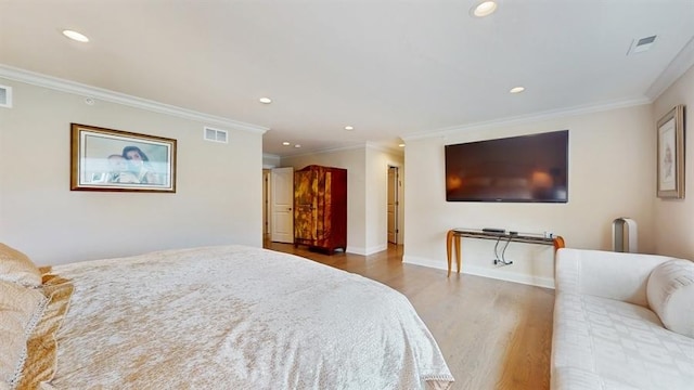 bedroom featuring crown molding, visible vents, and wood finished floors