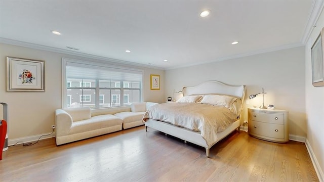 bedroom with light wood-type flooring, baseboards, and crown molding