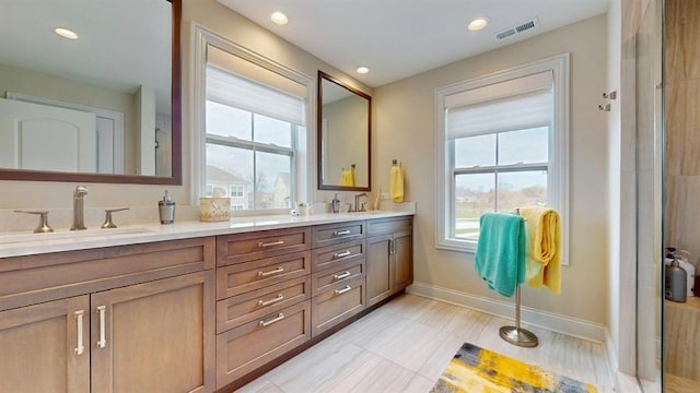 bathroom featuring double vanity, visible vents, baseboards, and a sink