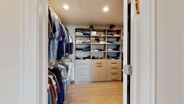 spacious closet featuring light wood-style floors and attic access
