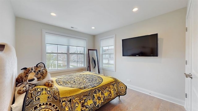 bedroom featuring baseboards, recessed lighting, visible vents, and wood finished floors