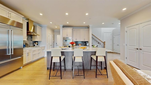 kitchen featuring backsplash, stainless steel appliances, crown molding, and wall chimney exhaust hood